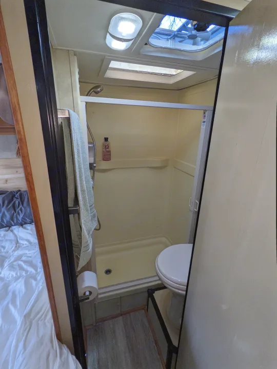 Inside an RV rental, showcasing a functional compact bathroom with a shower and toilet, designed for small spaces.. Thor Four Winds 2013