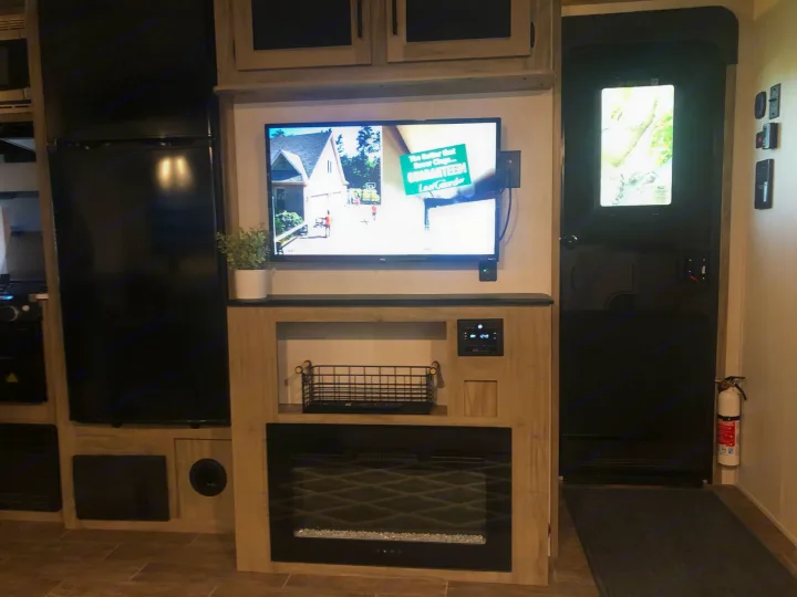 Experience this RV rental's inviting interior: TV, electric fireplace, kitchen fridge & entry door with safety extinguisher.. Forest River Cherokee Alpha Wolf 2022