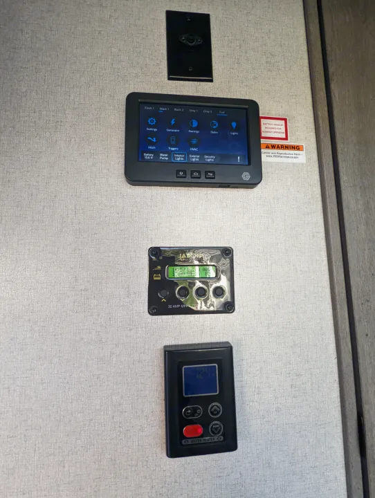 RV rental control hub: integrated panel for tank levels, lights, slides, HVAC, plus solar charger and water heater controls.. Keystone Raptor 2021