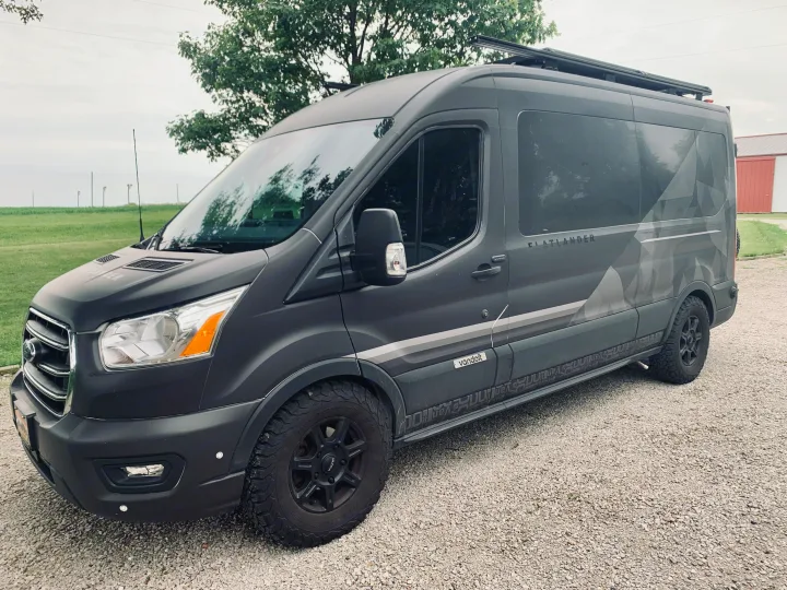 Dark gray Ford Transit Flatlander camper van by Vandoit, ideal for RV rental, parked on gravel.. Vandoit Vandoit Class B 2020