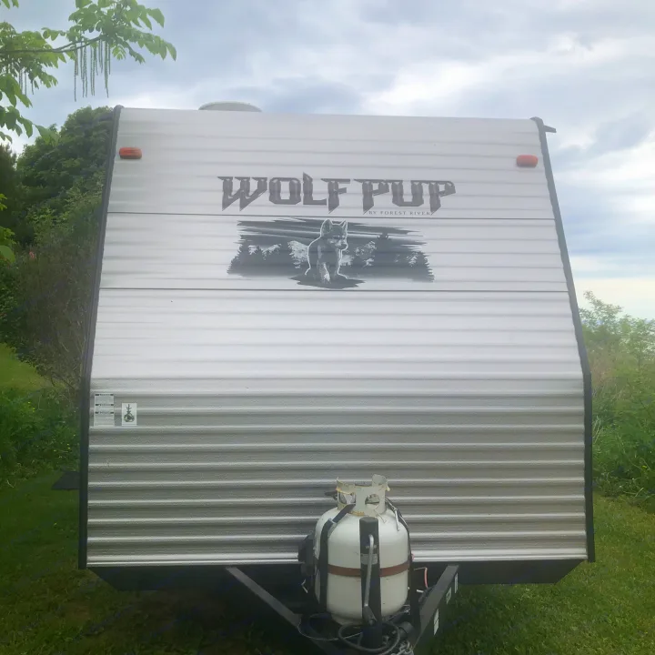 Front view of a "Wolf Pup" travel trailer, an RV rental option, with its LP gas tank. Great for camping trips!. Forest River Cherokee 2014