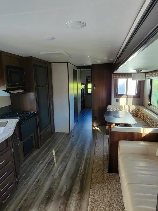 Inside a modern RV rental, showing a kitchen, dinette, and comfortable seating in the living space.. Jayco Jay Flight 2020