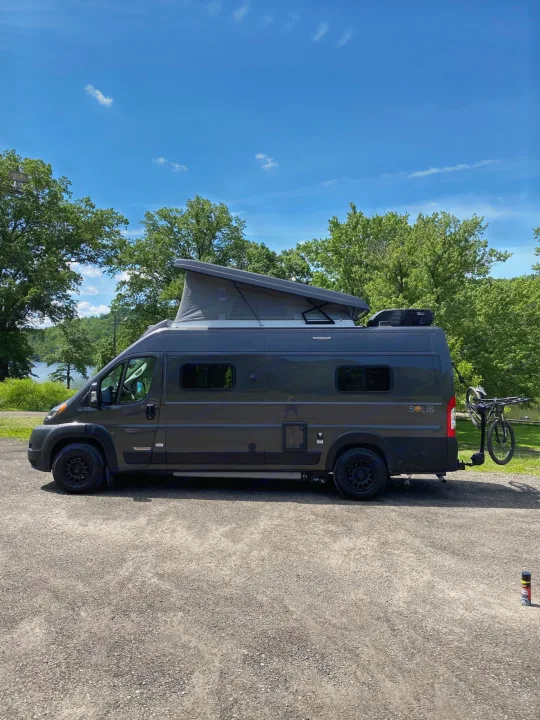 Dark grey Winnebago Solis camper van, pop-top extended, bike on rear rack. Ideal rv rental by the lake.. Winnebago Solis 2022