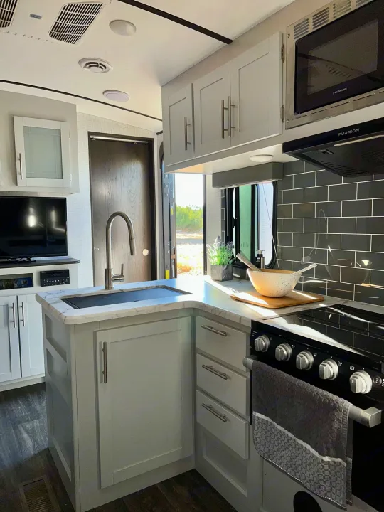 Spacious kitchen area with pots, pans, trash can and cleaning supplies under the sink. Keystone Bullet 2021