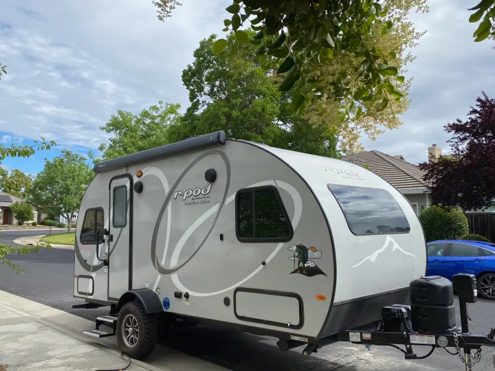 Forest River R-Pod travel trailer RV rental in light gray, parked on a street in a residential area.. R-Pod R-Pod Trailer 2021