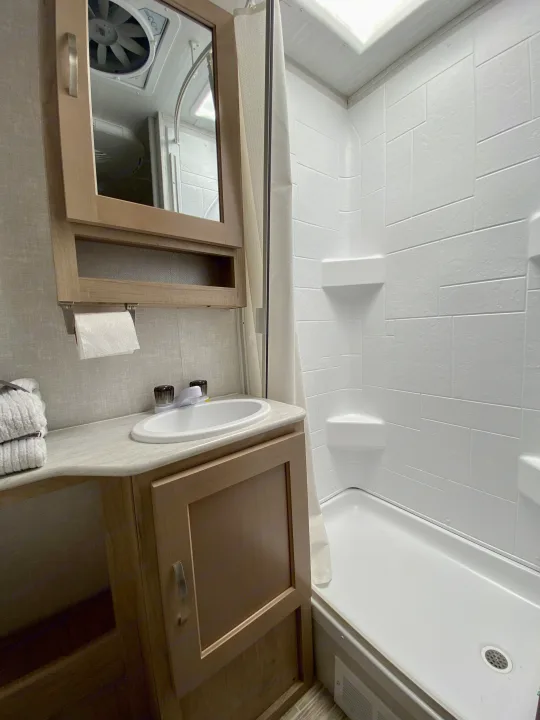 Clean RV rental bathroom with a sink vanity, toilet paper holder, and compact shower stall, ready for your trip.. R-Pod R-Pod Trailer 2021