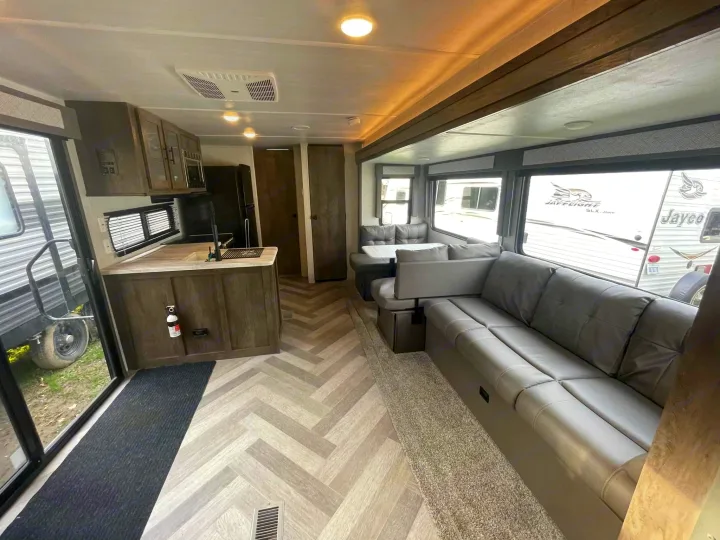 Step inside this modern RV rental. It features a full kitchen, dinette, and plush gray sofa, perfect for comfortable travel.. Salem 36VBDS 2021