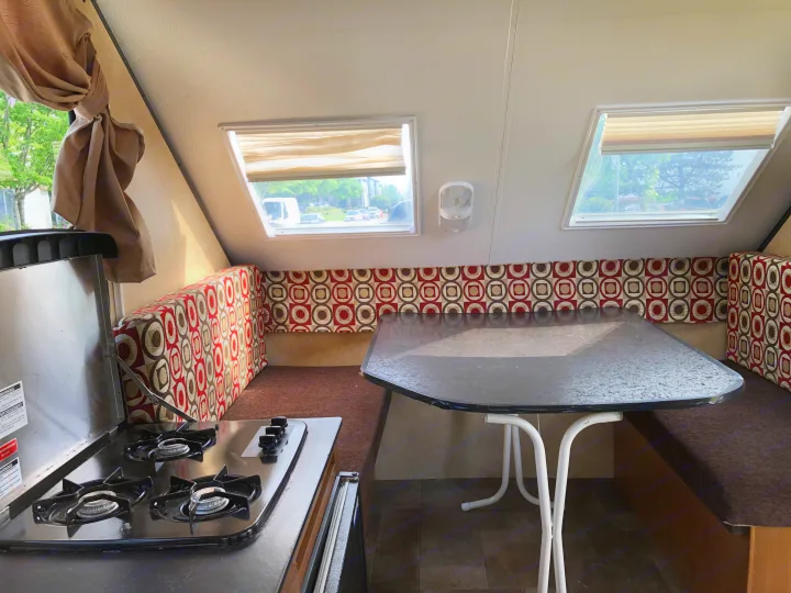 RV rental interior: cozy dinette and compact kitchen with stove, perfect for travel trailer adventures.. Starcraft Comet 2015