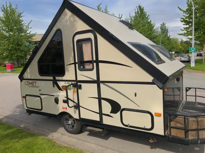 Comet A-frame pop-up rv rental, light beige with black trim, showing windows, skylights, and rear cargo.. Starcraft Comet 2015