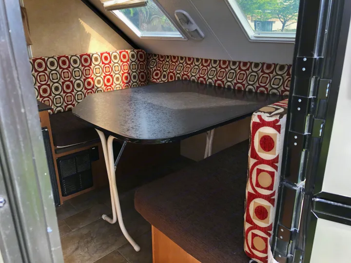 RV rental dinette: patterned seating, dark table, and bright skylights create a comfortable interior space.. Starcraft Comet 2015