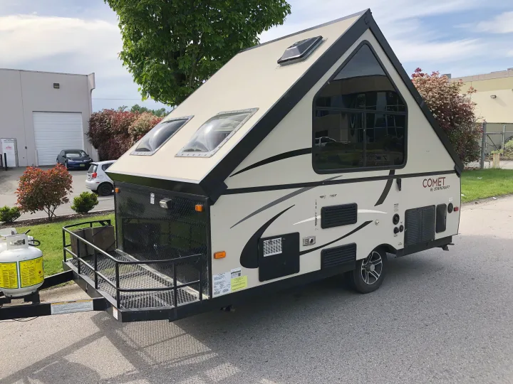Beige Comet by Starcraft A-frame travel trailer, ideal for an RV rental, parked outdoors on asphalt.. Starcraft Comet 2015
