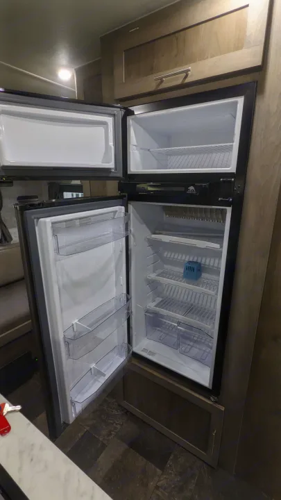 Clean, open Norcold refrigerator and freezer in an RV rental, showcasing the empty, ready-to-use interior.. Prolite RV Evasion 16 2022
