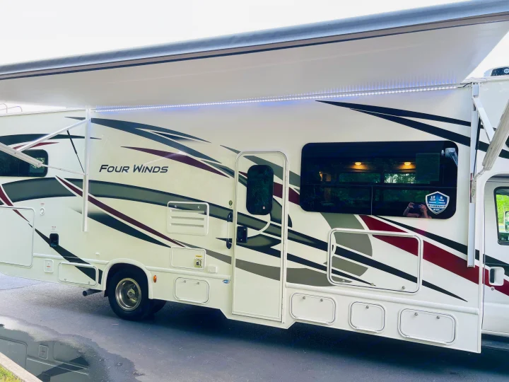 This "Four Winds" RV, ready for your next adventure or rv rental, features an illuminated awning and sleek design.. Four Winds 31E 2022