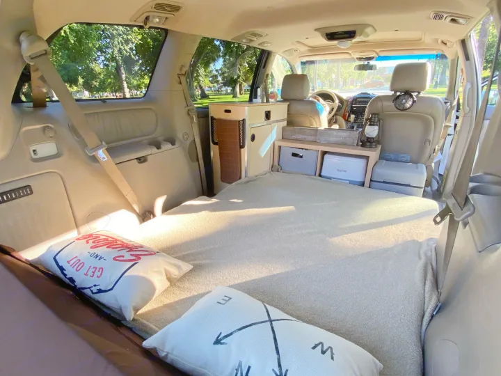 Cozy minivan camper conversion perfect for an rv rental adventure. Features a comfy bed, compact kitchen, & storage for road trips.. Custom Camper 2004