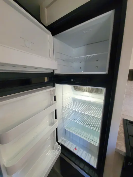 Clean, empty two-door refrigerator and freezer in an RV rental. Ready for groceries on your next adventure.. Jayco Jayco Jay Flight SLX 264bhw 2022