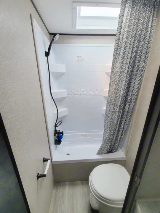 This RV rental bathroom offers a full shower/tub combo, toilet, and built-in shelving, all within a compact, clean design.. Jayco Jayco Jay Flight SLX 264bhw 2022