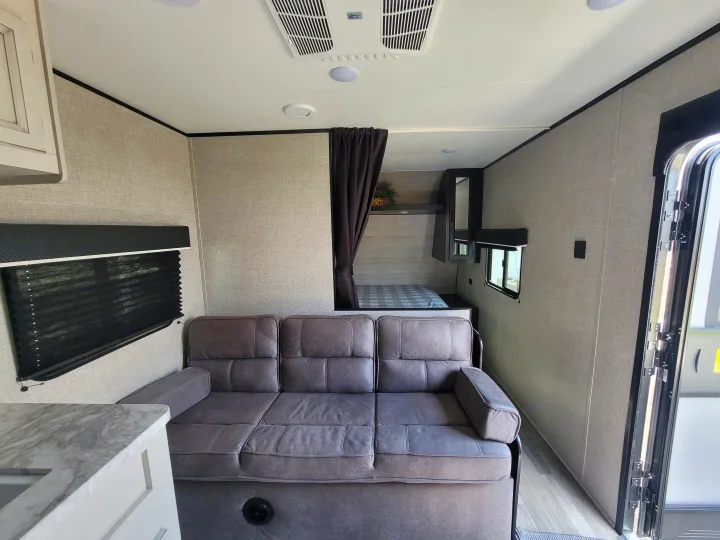 Inside an rv rental: spacious living area with a sofa, leading to a compact sleeping nook.. Jayco Jayco Jay Flight SLX 264bhw 2022