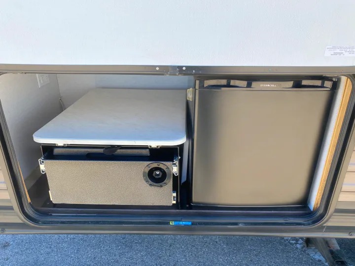 RV rental outdoor kitchen featuring an Ever Chill mini-fridge, a portable table, and a pull-out unit with a gas connection.. Forest River Wildwood X-Lite 2019