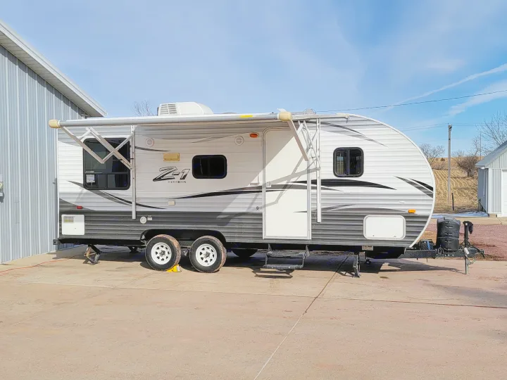 This Z-1 travel trailer, ready for your next rv rental adventure, is parked outside with its awning extended.. Crossroads RV Z-1 2015