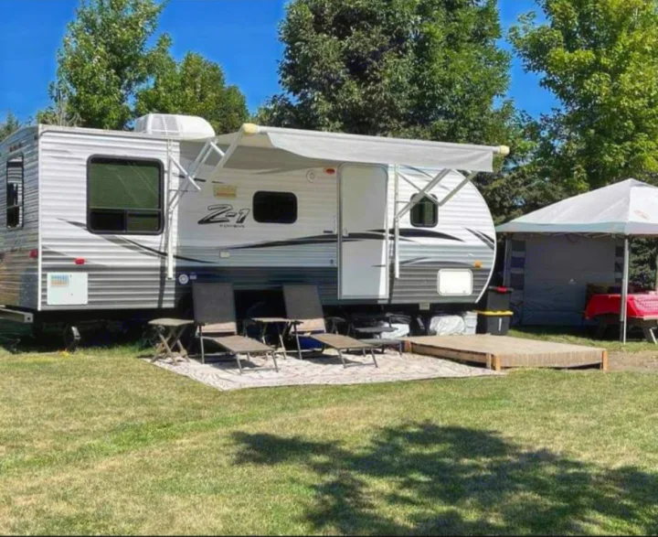 RV rental: Spacious travel trailer campsite with extended awning, outdoor living area, and side tent setup.. Crossroads RV Z-1 2015