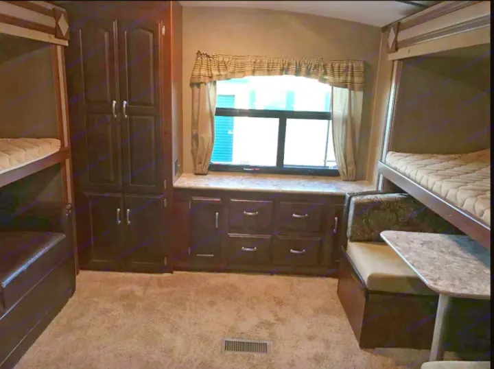 Spacious RV rental bunkhouse interior with multiple bunk beds, window, ample storage, and a dinette area.. Other Outback 2017