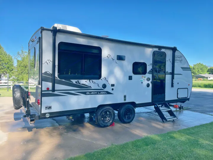 Sleek grey and black travel trailer, perfect for an RV rental. Parked outside with steps deployed.. Forest River Cherokee Grey Wolf 2021