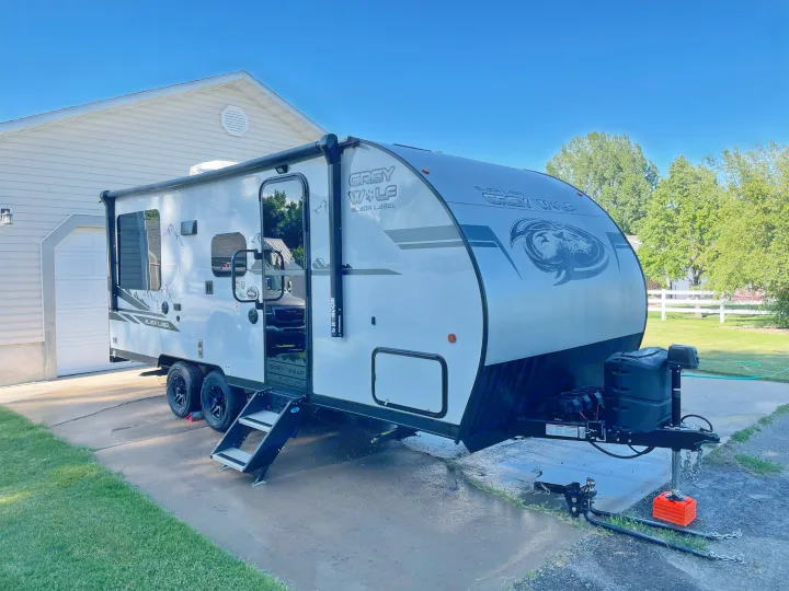 Grey Wolf RV travel trailer, white and black, parked on a paved driveway with entry steps down. Excellent for an RV rental.. Forest River Cherokee Grey Wolf 2021