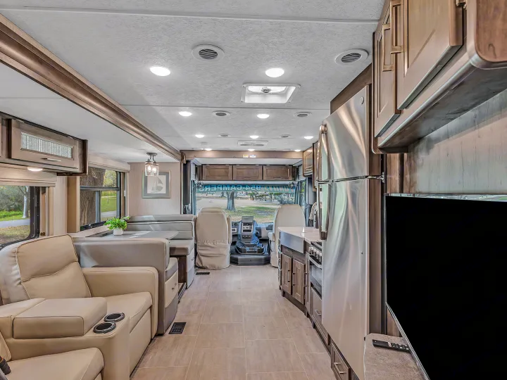 This RV rental offers a modern interior with a full kitchen, comfortable recliners, dinette, and driver's cockpit.. Coachmen Mirada 2021