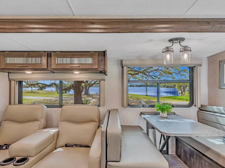 Spacious RV rental with comfy recliners, dinette, and large windows offering scenic lake views.. Coachmen Mirada 2021