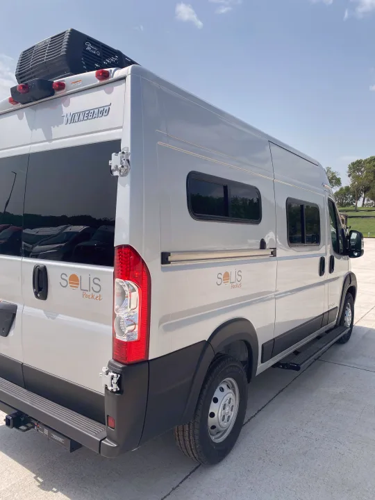 Winnebago Solis Pocket camper van, an RV rental, captured from the rear-side, featuring its roof AC and step.. Winnebago pocket 2023