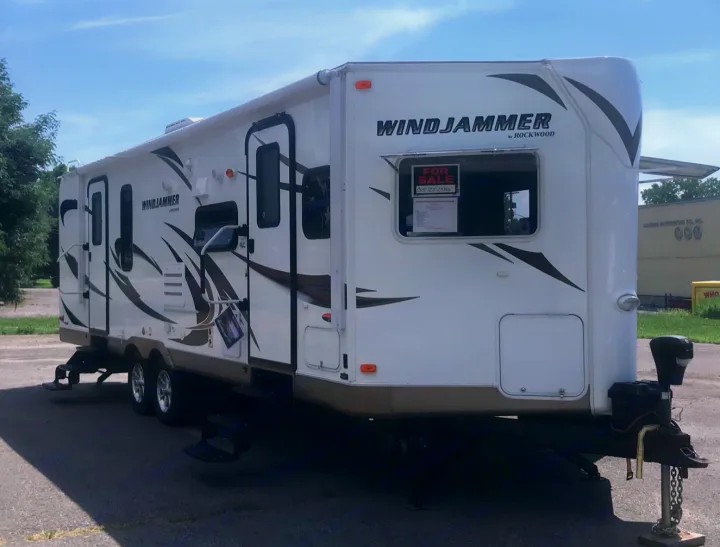 White Windjammer travel trailer, an ideal RV for rental, is for sale. Parked outdoors on asphalt.. Forest River Rockwood Windjammer 2012