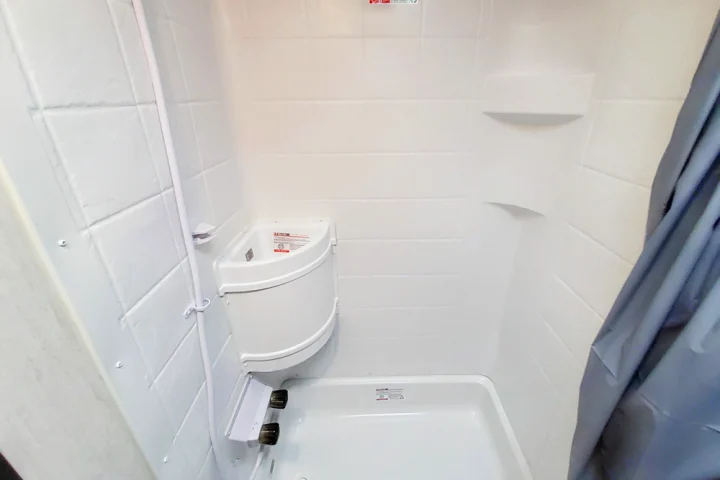 This compact RV rental shower offers a built-in sink, shower pan, and shelves, providing essential amenities in a small space.. Forest River Cherokee Wolf Pup 2022