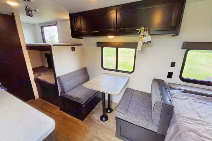 Inside a bright RV rental: features bunk beds, a cozy dinette with benches, and a comfortable sleeping area.. Forest River Cherokee Wolf Pup 2022