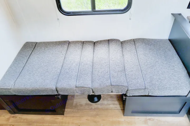 RV rental: Gray cushions arranged as a comfortable bed, showcasing a versatile RV interior feature for sleeping.. Forest River Cherokee Wolf Pup 2022