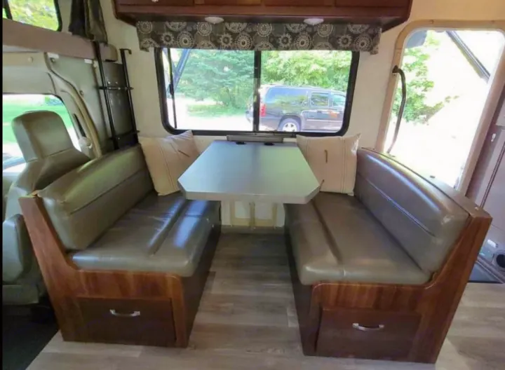 RV rental: View of a compact dinette with two facing benches, a table, and large windows offering a nature view.. Forest River Sunseeker 2017