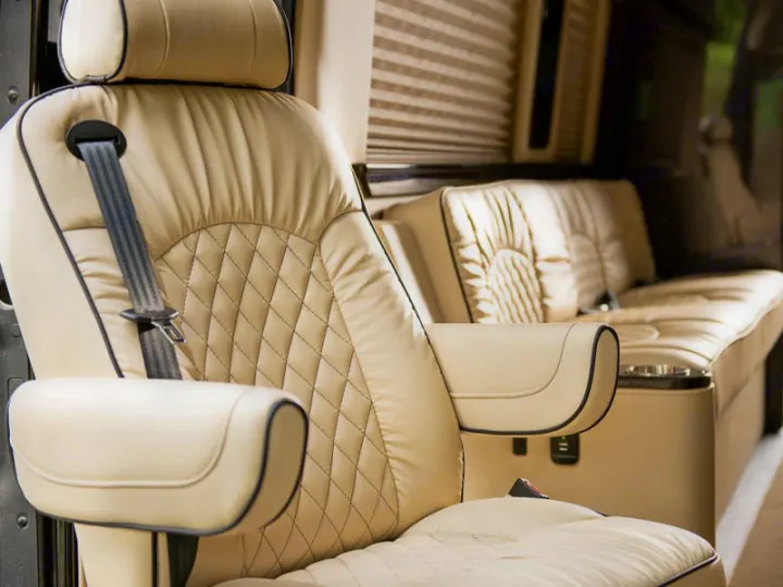 RV rental: Luxurious cream captain's chair with diamond stitching and armrest, showing plush vehicle interior.. Ultimate Toys Ultimate Traveler 2023