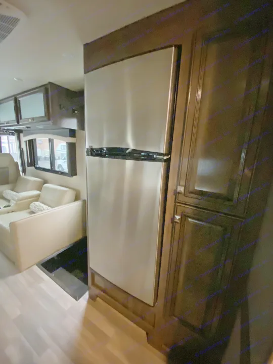 RV rental interior: A full-size stainless steel refrigerator, dark wood cabinets, and comfortable seating define this modern space.. Flair-Fleetwood Flair-Fleetwood Motorhome 2020