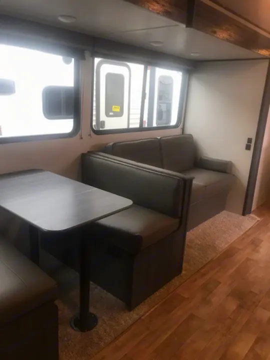 This RV rental offers a comfortable dinette and lounge seating. Ideal for trips, well-lit with multiple windows.. Keystone Hideout 2022