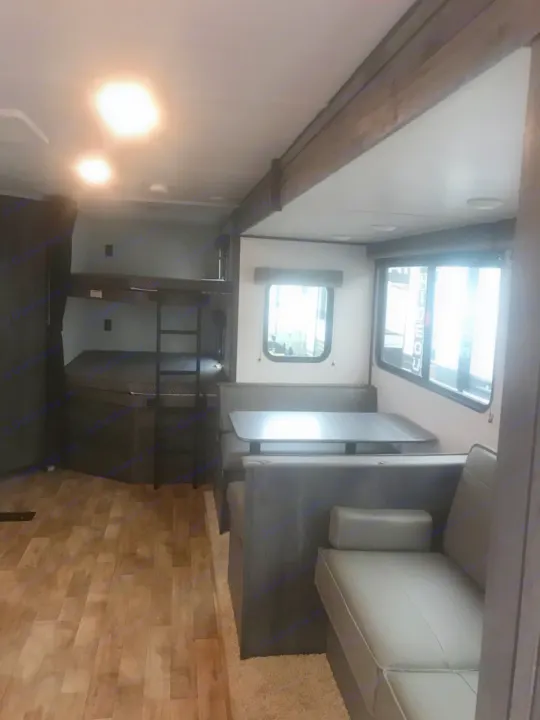 Experience comfort in this RV rental's spacious interior, featuring bunk beds, a dinette, and sofa seating.. Keystone Hideout 2022