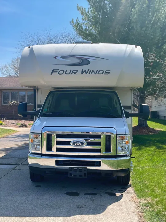Front view of a white Ford Four Winds Class C motorhome, perfect for an RV rental adventure. Parked on a sunny driveway.. Thor Motor Coach Four Winds 2019