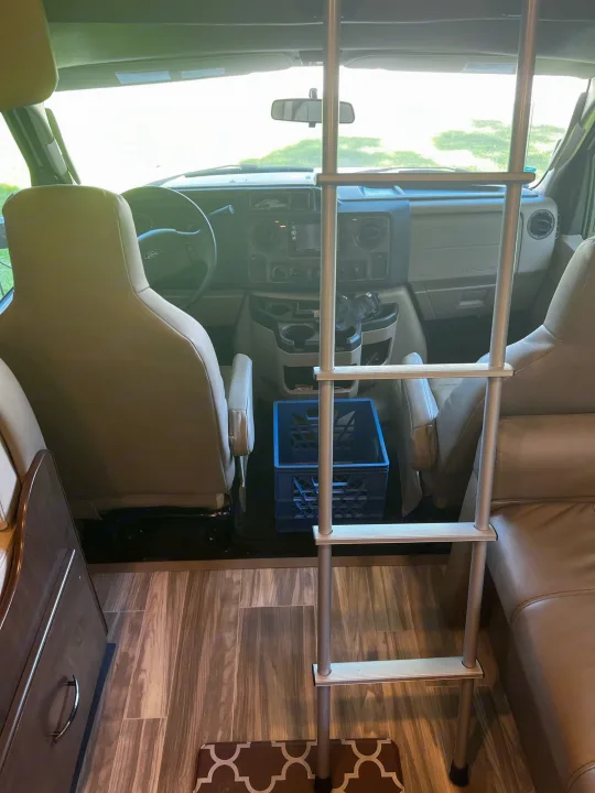 Inside an RV rental: front cabin with seats, dashboard, and a ladder for bunk access. Ready for adventure!. Thor Motor Coach Four Winds 2019