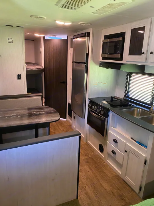 RV rental interior: full kitchen, dinette, & bunks. Perfect for family adventures on the road.. Heartland RVs Trailrunner 2021