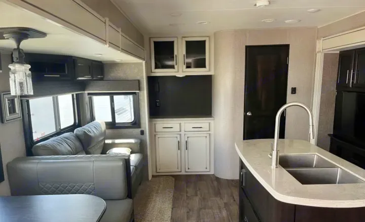 Spacious RV interior with kitchen island, living area with sofa & dining, and modern decor, perfect for an RV rental.. Jayco Eagle HT 2020