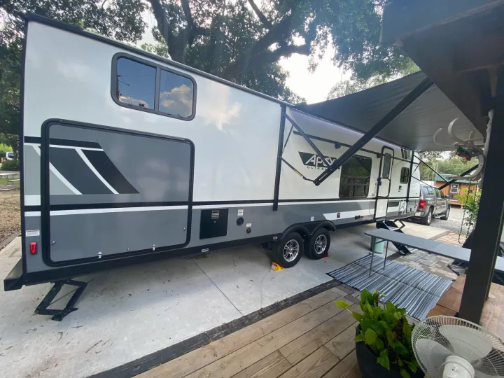 Modern Apex Ultra RV rental parked with awning extended, creating an inviting outdoor space on a concrete pad.. Forest River two bedroom Apex ultralite 2022