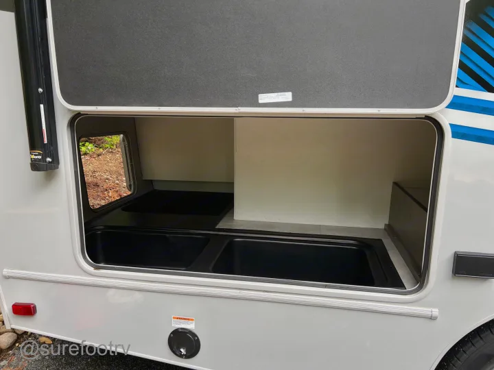 RV rental exterior storage compartment, open to show deep black bins for gear. Essential space for your trip.. Forest River Coachmen Cross Trail XL 2022