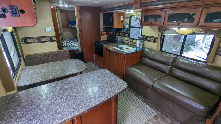 Spacious RV rental interior featuring a kitchen, dining area, comfortable sofa, and bunk beds, ready for adventures.. Heartland RVs North Trail 2013