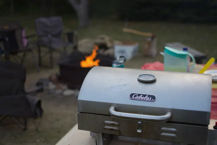 Enjoying a Cabela's grill and warm campfire, perfect for outdoor cooking during your RV rental adventure.. Heartland RVs North Trail 2013