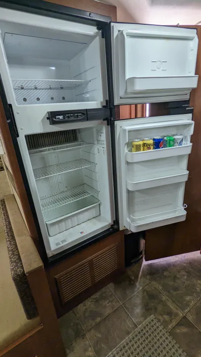 RV rental: Open fridge/freezer with empty shelves & door shelves holding drinks. Ready for road trip food storage!. Heartland RVs North Trail 2013