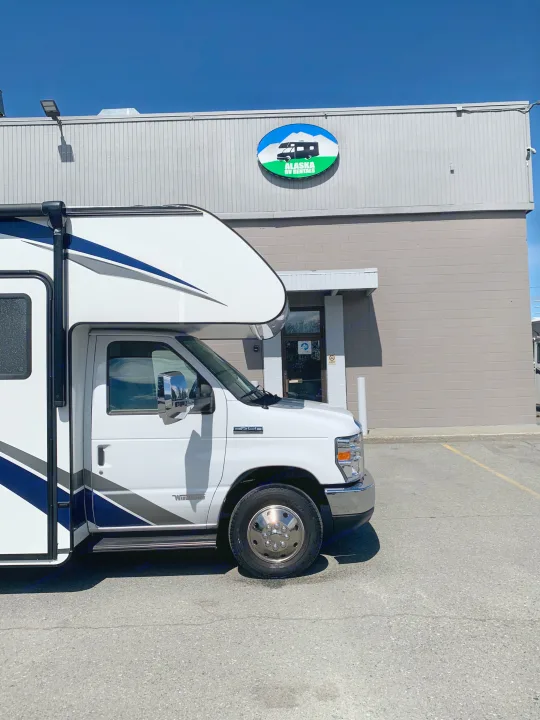 White Winnebago Class C motorhome for rv rental, parked at Alaska RV Rentals office under a clear blue sky.. Winnebago Outlook 2020