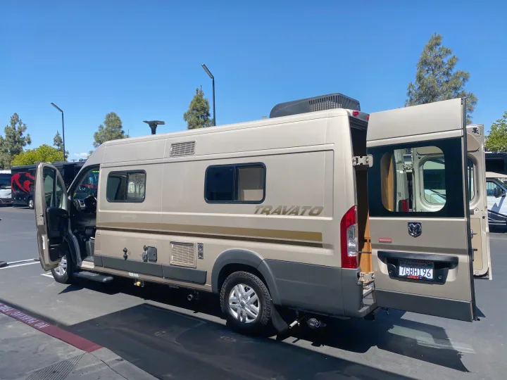 Explore this Winnebago Travato camper van, an ideal RV rental, showcasing its open doors on a sunny day.. Winnebago Travato 2014